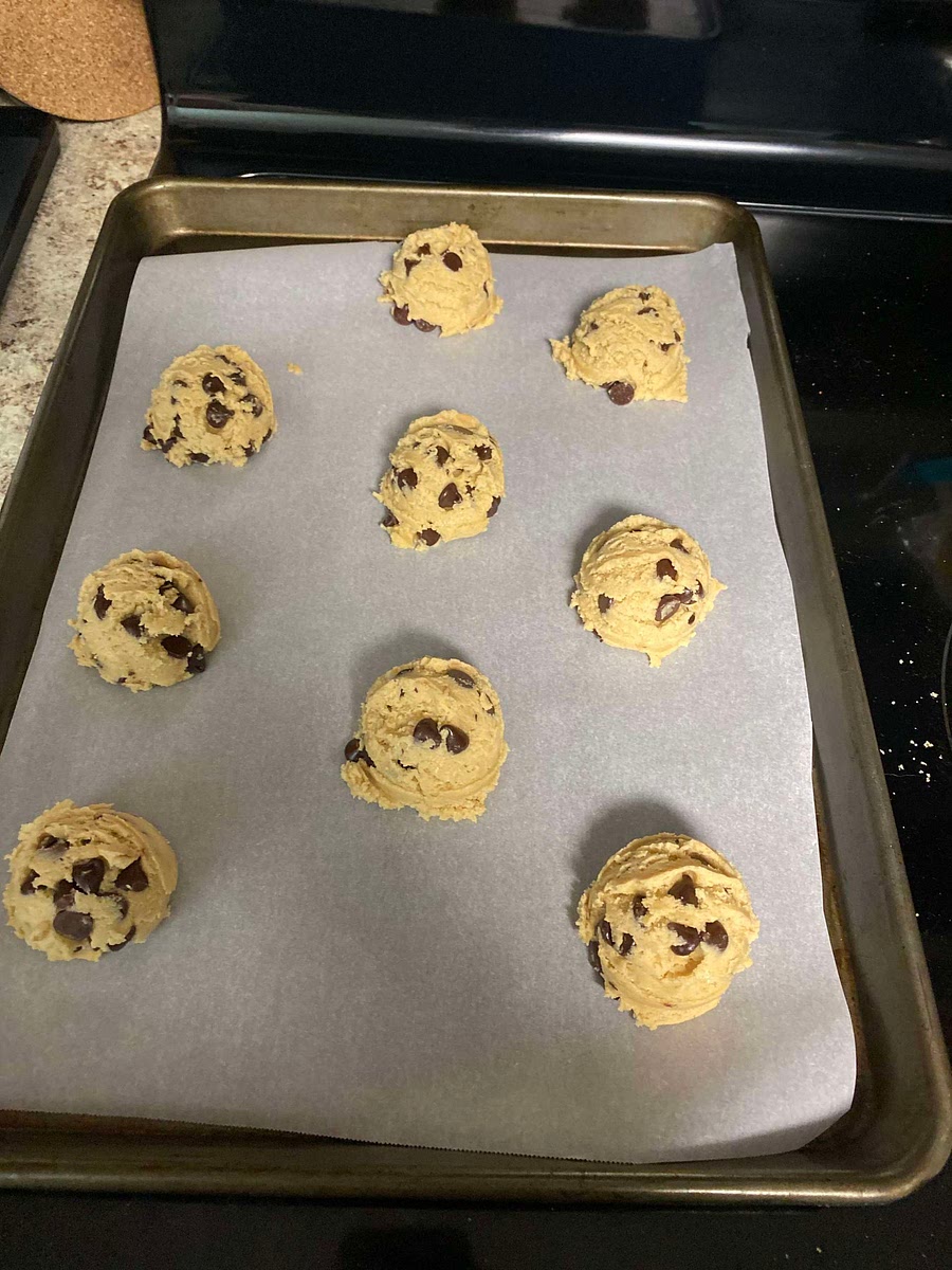 Drop rounded measured big ice cream scooper sized balls onto a parchment paper lined baking sheet spaced 2-3 inches apart for room to expand.