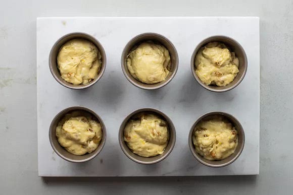 Grease the baba molds and divide the dough evenly among them. Position a rack in the center of the oven and heat to 400 F. Cover the molds and allow the dough to rise until the dough has just started to rise above the molds’ edges, 30 to 45 minutes.