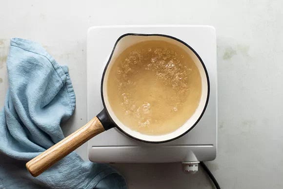 In a medium saucepan set over medium heat, bring the water and sugar to a boil until the syrup has thickened, 5 to 10 minutes.