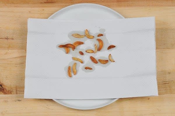 Cook the Garlic Chips
Line a plate with a paper towel. Slice garlic very thinly. Slice as thin and uniformly as possible. Add 2 tsp. olive oil to a large non-stick pan, then add garlic slices in a single layer. Place pan over medium heat. As soon as oil begins to bubble, turn heat to low. Cook until garlic slices dry out and begin to brown, 10-15 minutes. Immediately remove browned slices to towel-lined plate. Reserve oil and pan. While garlic cooks, prepare ingredients and cook pasta.