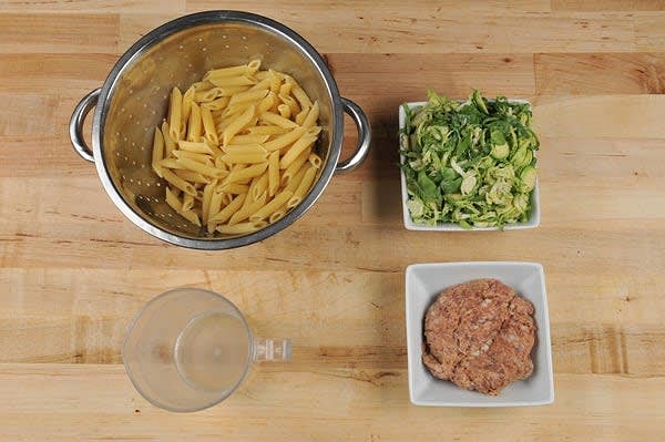 Cook Pasta and Prepare Ingredients
Once water is boiling, add pasta and cook until al dente, 10-12 minutes. Reserve 1/4 cup pasta cooking water. Drain pasta in a colander and set aside. While pasta cooks, trim stems off Brussels sprouts and thinly slice. On a separate cutting board, remove Italian sausage from casing, if necessary.
