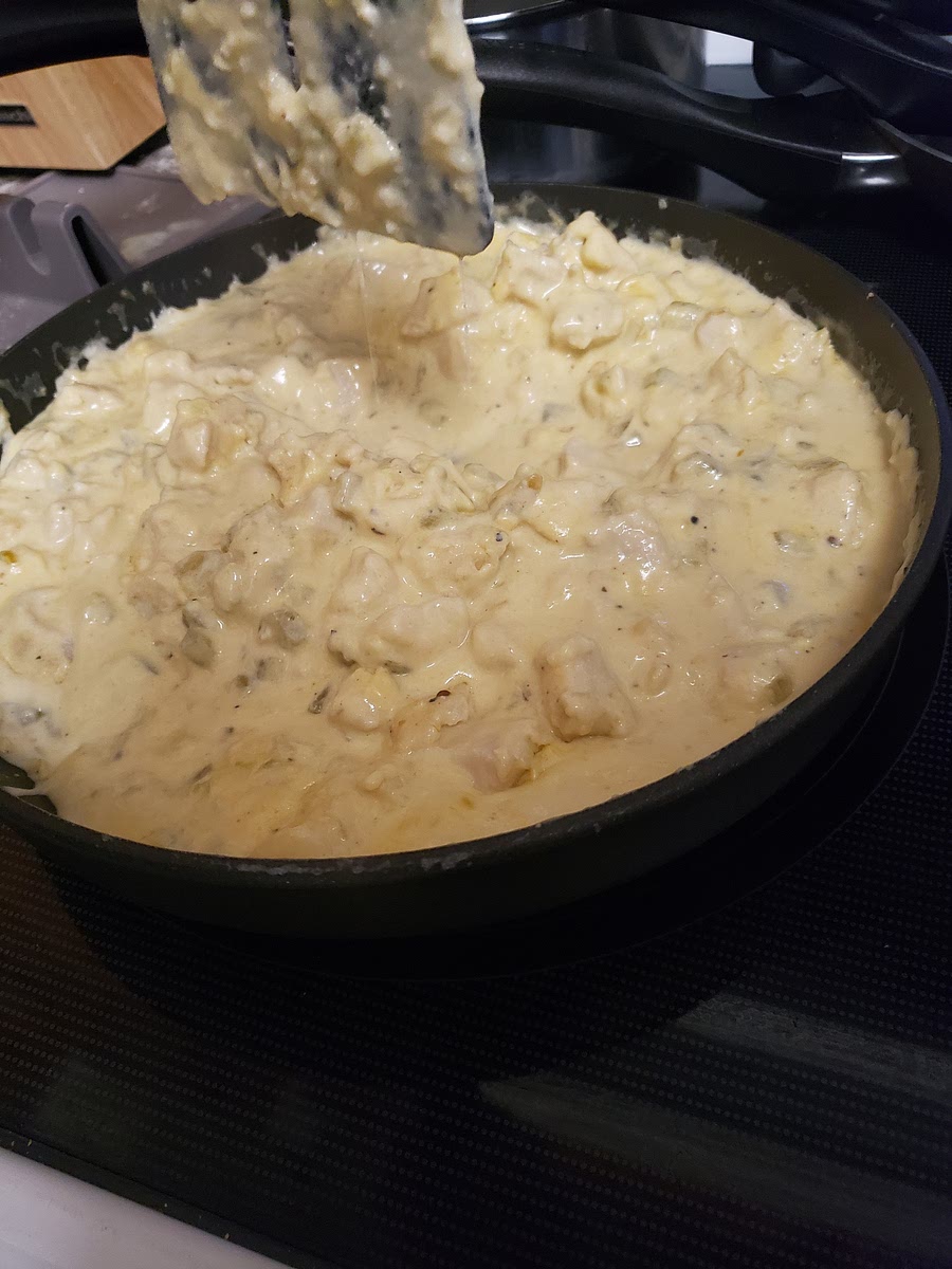 In a pan, cook diced chicken, roasted garlic seasoning, some chopped onion, salt and pepper. When the chicken is cooked, add chilies, sour cream, and cheese.