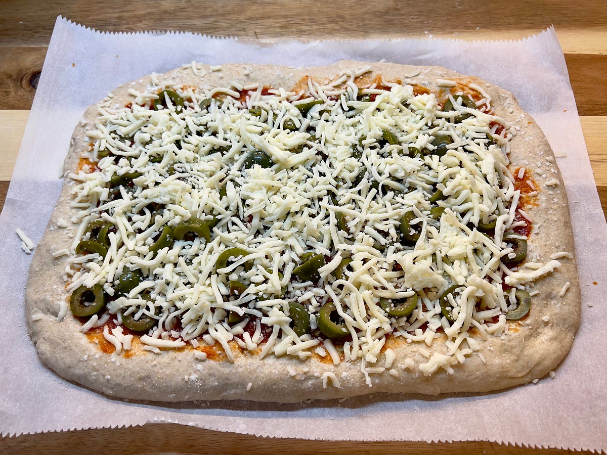 Spread your sauce and add the toppings and cheese (except the basil leaves)