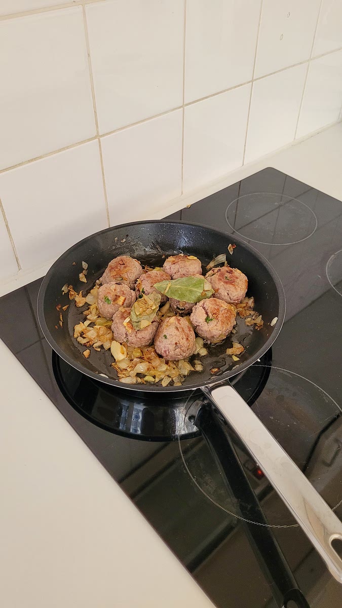Leg de balletjes in de pan bij de ui en laat alles goudbruin worden, voeg eventueel nog een scheutje olijfolie toe