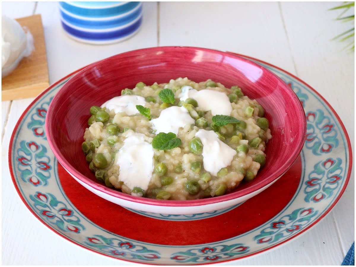 Il risotto ai piselli è pronto, non vi resta che impiattarlo, completarlo con burrata e menta e servirlo.