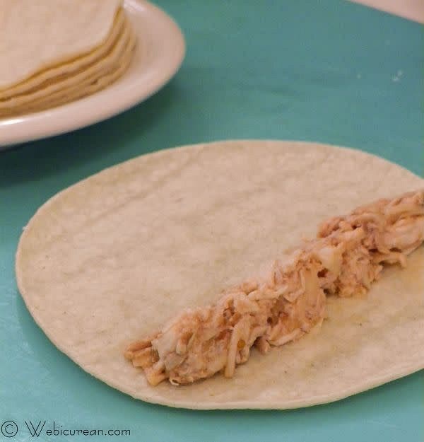 Heat the tortillas in the microwave–place on a microwave-safe dish, cover with a damp paper towel, and zap for about 30 seconds. This will make them more pliable so they won’t crack. Spread about 2 tablespoons of the chicken mixture across the tortilla, and roll it up tightly.