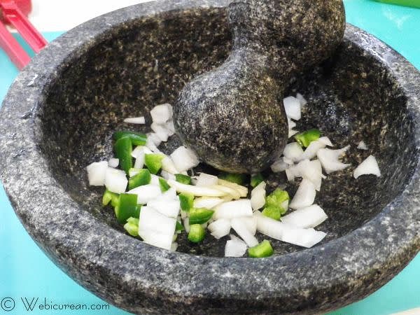 While the tacos are cooking, make the guacamole in a molcajete if you have one. First crush the onion, garlic, and jalapeno in the bowl. Next grind in the cilantro, then mash the avocados in one at a time, until the desired consistency is reached.