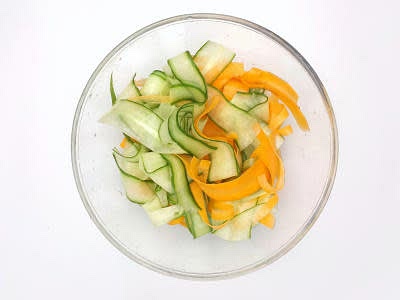 Peel the carrot[s], then continue to peel lengths until you end up with a pile of carrot ribbons Peel lengths off the cucumber until you end up with a pile of cucumber ribbons Add the carrot and cucumber ribbons to a large bowl with the rice vinegar and a pinch of salt and set aside to pickle