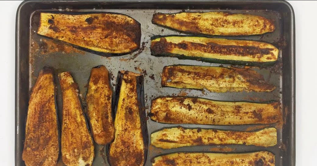 Preheat the oven to 220°C/ 200°C (fan)/
gas 7
Top, tail and slice the aubergine|s] and
courgettes] lengthways
Add the sliced aubergine and courgette
to a baking tray (or two!) with the ras el
hanout, a generous pinch of salt and olive oil