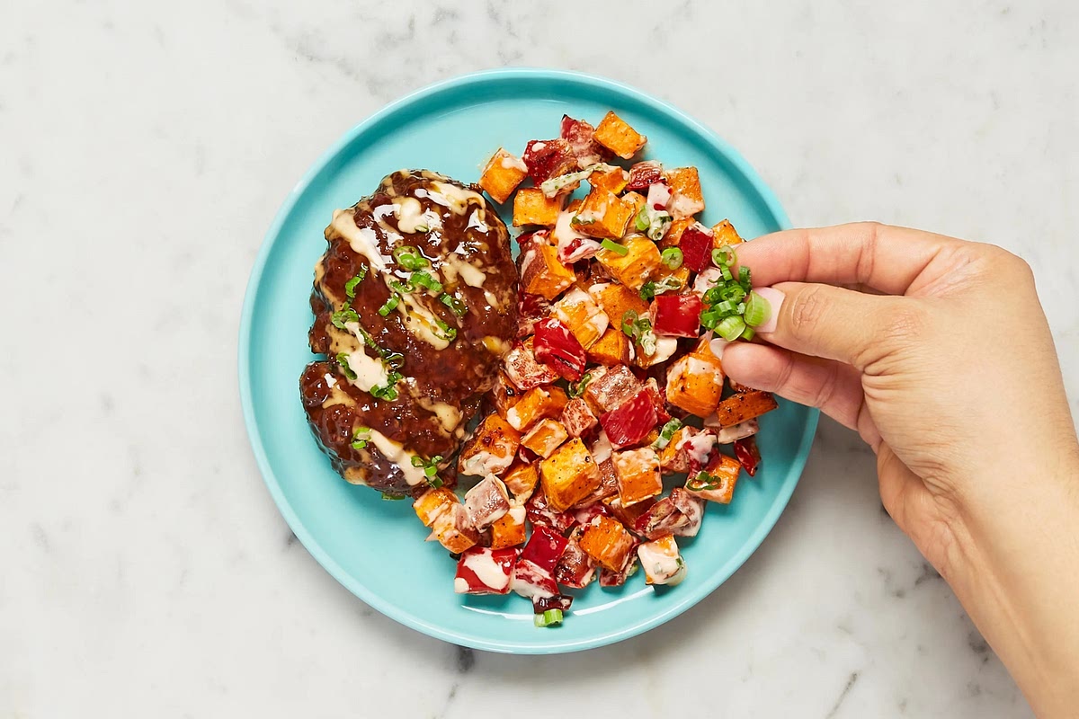 Top meatloaves with remaining sweet soy glaze. Drizzle meatloaves and veggie jumble with spicy lime mayo and sprinkle with scallion greens. Divide between plates and serve.