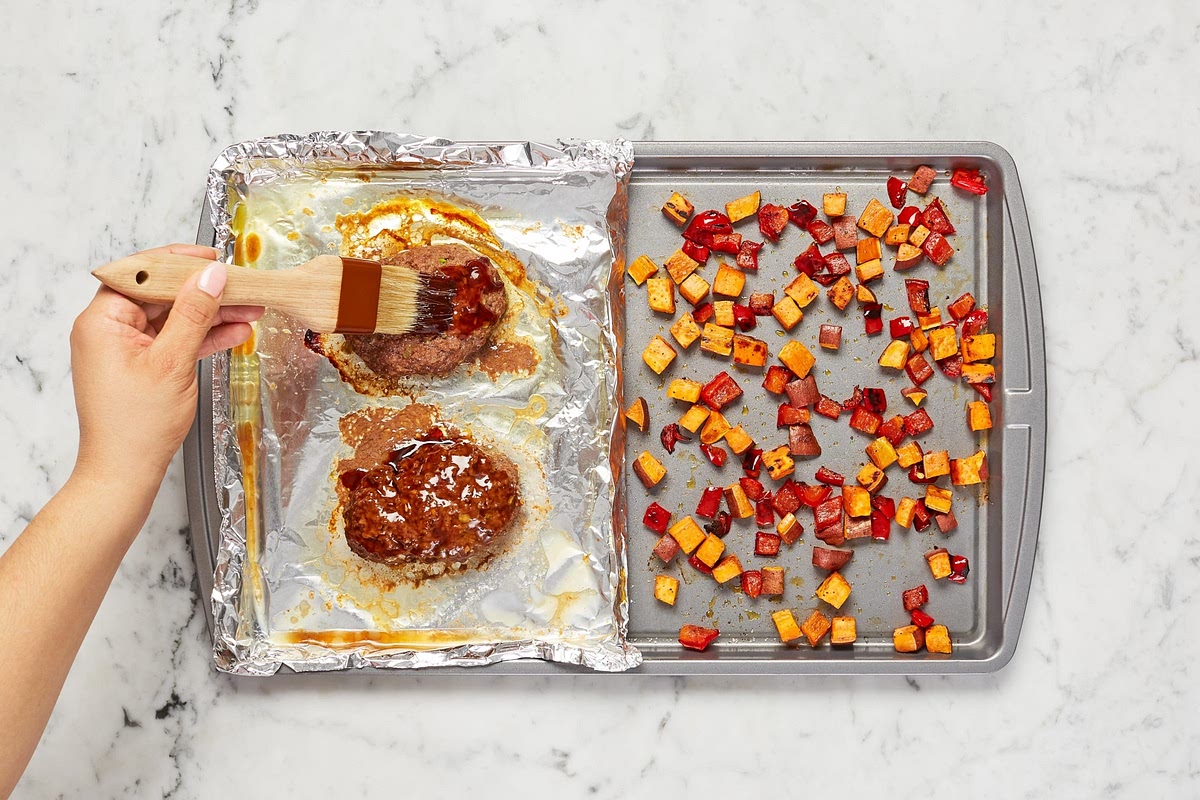 Once meatloaves and veggies have roasted 20 minutes, remove sheet from oven. (For 4 servings, leave veggies roasting.) Carefully brush meatloaves with half the sweet soy glaze (save the rest for serving). • Return to top rack until meatloaves are cooked through, glaze is tacky, and veggies are tender, 3-5 minutes more.
