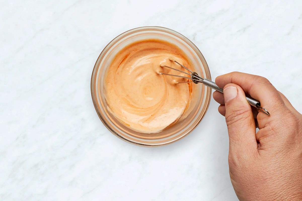 Meanwhile, in a small bowl, combine mayonnaise with a squeeze of lime juice to taste and as much Sriracha as you like.