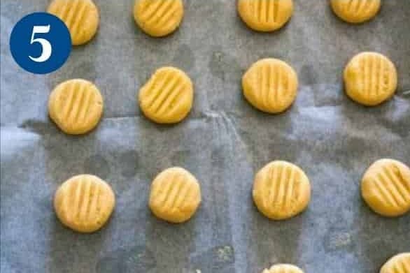 Place the balls on a parchment-lined, cookie sheet. Use a fork to flatten and mark the top.