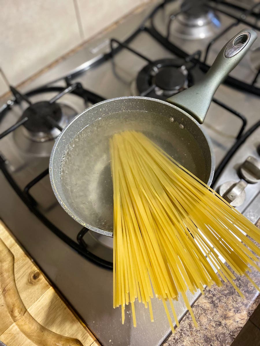 First boil some spaghetti in a pot with a pinch of salt and a teaspoon of oil and stir it with tongs