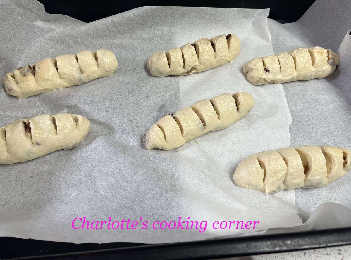 Roll it to flat with rolling pin. Fold the dough in from both side to make it the oval shape. Cut 3-5 lines with scissors but don't cut it off.