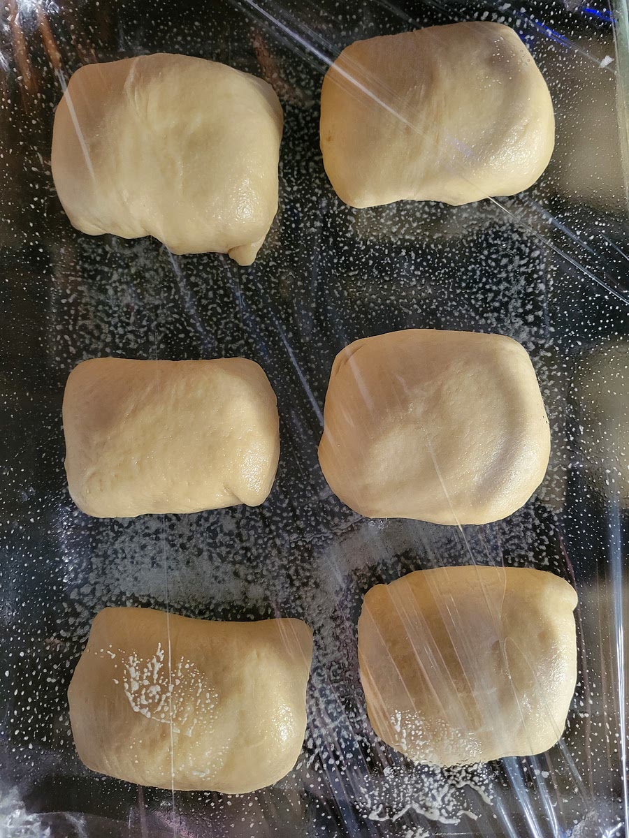 PLACE DOUGH ONTO A GREASED BAKING SHEET AND COVER LOOSELY WITH GREASED PLASTIC WRAP. 10. ALLOW TO DOUBLE IN SIZE AGAIN, ABOUT 1 HOUR.
