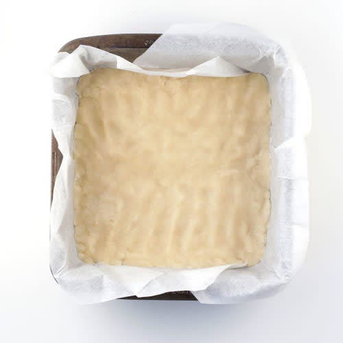 In a medium bowl, add the melted vegan butter, sugar, vanilla extract, and salt. Mix to combine. Lastly add the flour and mix to make a firm dough. Dump the dough into the prepared pan and press with your fingers to firmly pack and evenly spread the dough. Bake for 17 - 19 minutes until the dough is golden around the edges. Remove from the oven and if there are any bubbles you can poke them with a fork to remove them. Set aside.