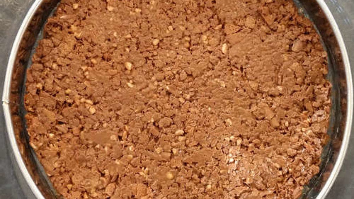 Faire fondre la tablette de chocolat au praliné. Pendant ce temps émietter grossièrement les crêpes dentelles.
Mélanger les deux ensembles et déposer la préparation au fond d’un moule recouvert de papier cuisson.
Réserver au frigo.