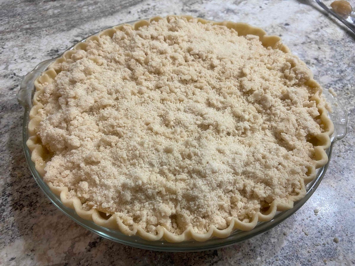 In a medium bowl mix with a fork or hands: flour, both sugars, and butter until everything is crumbly. Sprinkle over apples