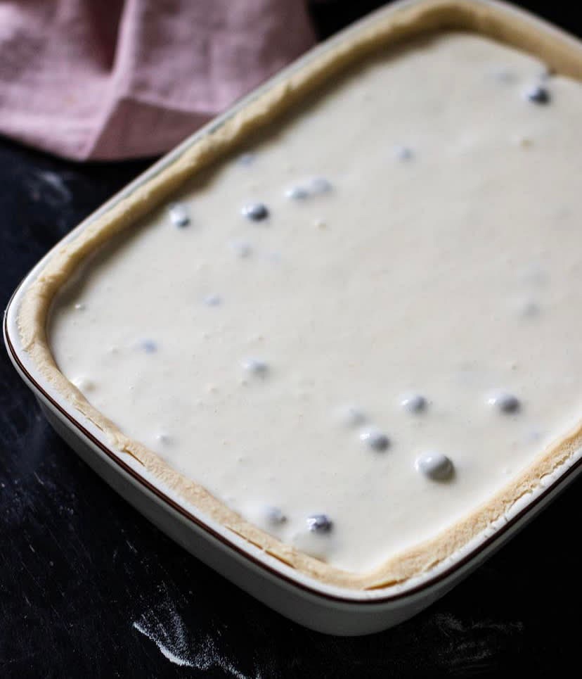 Pour the cream over blueberries and dough