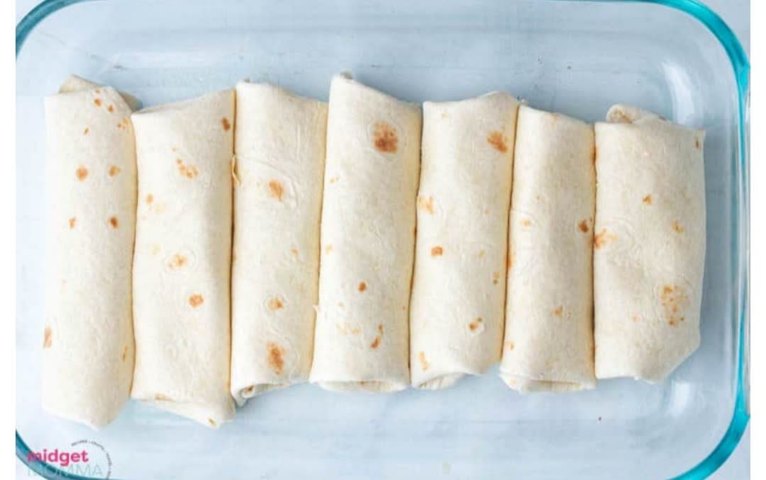 In each tortilla shell add in some chicken and cheese mixture roll up and place in the baking dish.