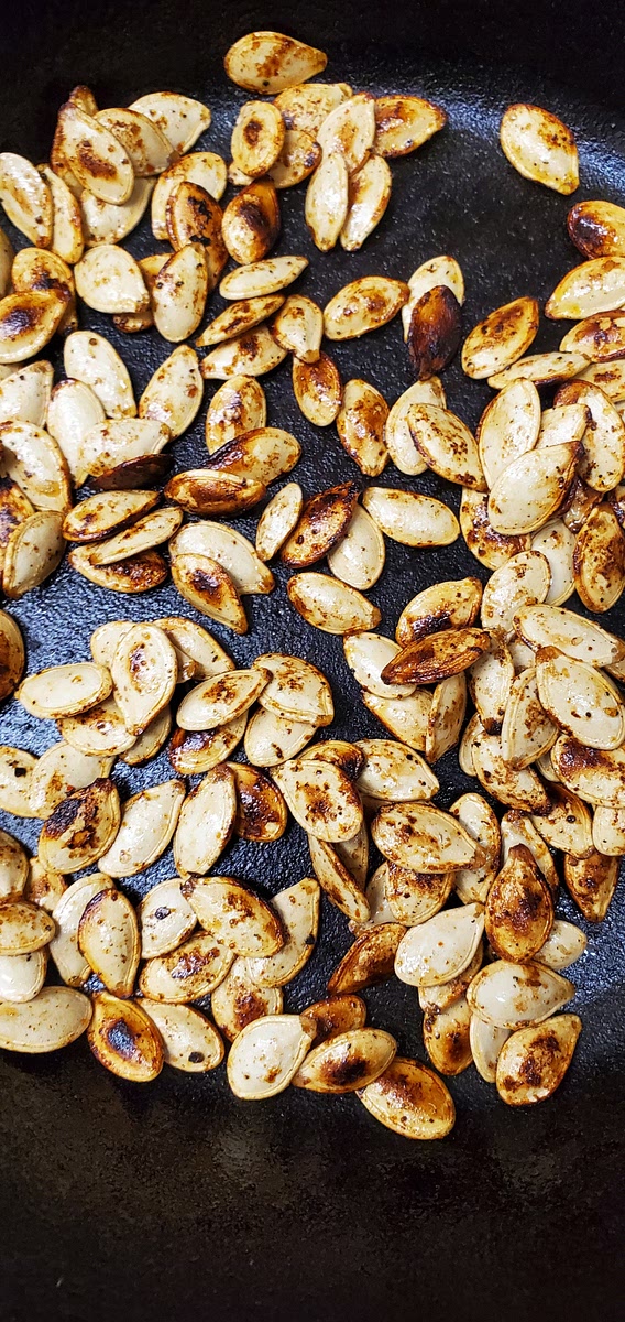Clean the pumpkin seeds with cold water. Boil for 10 minutes with salt. Drain the water afterwards. Transfer the seeds into a bowl. Add all the ingredients. Mix well. Then roast them in an iron pan without adding more oil. Stir constantly until they start to change colors and pop. Roast for 5 minutes. Then it's ready to eat.
