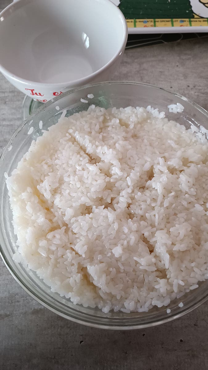 Transférer le riz dans un plat adapté (hangiri en bois, terrine en grès, à défaut un saladier en plastique, SURTOUT pas métallique), puis verser le mélange de vinaigre de riz dessus, puis mélanger.
(Il ne faudrait pas tasser le riz dans le saladier, ni trop mélanger pour ne pas casser les ams de riz.
Éventuellement il est possible de faire des silons dans le riz pour mieux disposer le vinaigre)