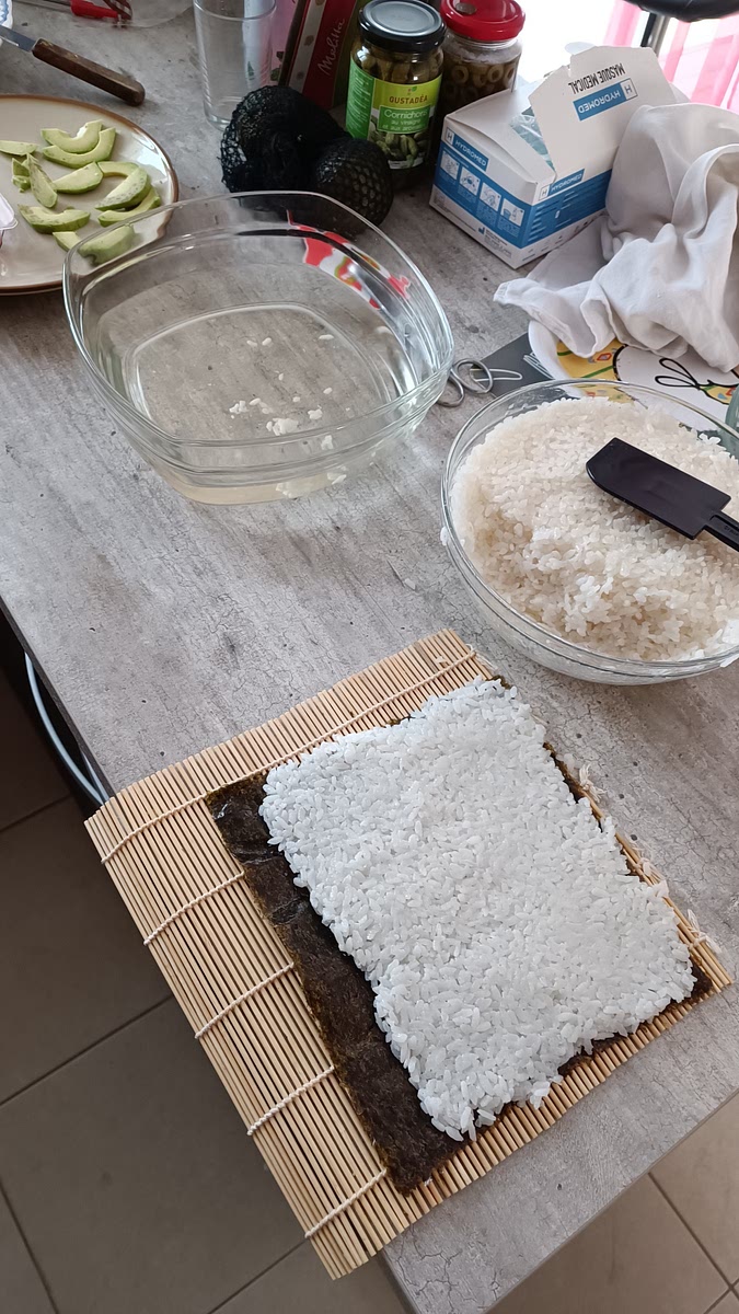 Repartir du riz sur la feuille d'algue, en laissant une marge dans la partie inférieure.