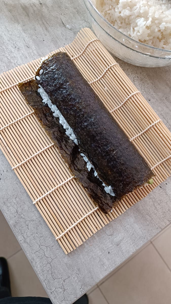 Rouler le maki.
Humidifier la bande restante, pour que l'algue adhère correctement en fermant le maki
