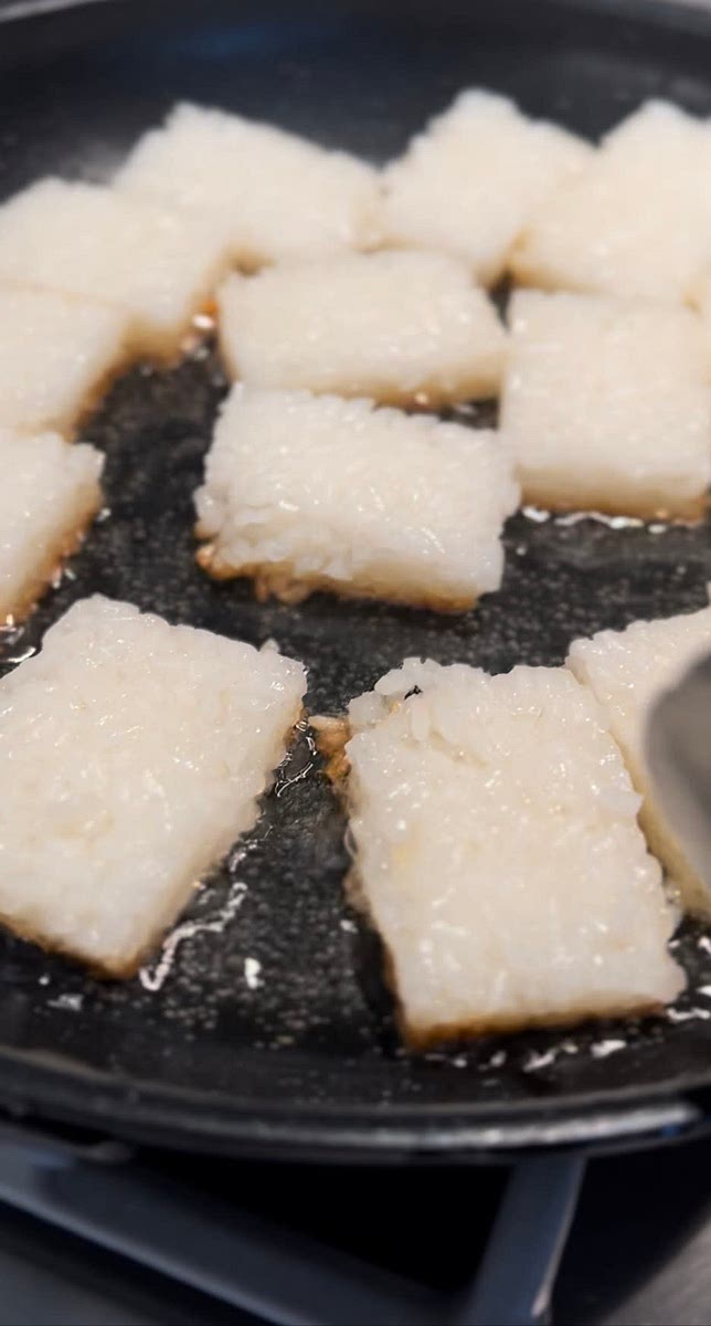After the rice is chilled and set, cut into squares or rectangles To a large pan, add a little vegetable oil over medium high heat. Once the oil is very hot, add the rice squares and shallow fry in batches to not over-crowd them. Once the bottom is golden, flip over and allow the other side to become golden while making sure to flip carefully to not break it.
