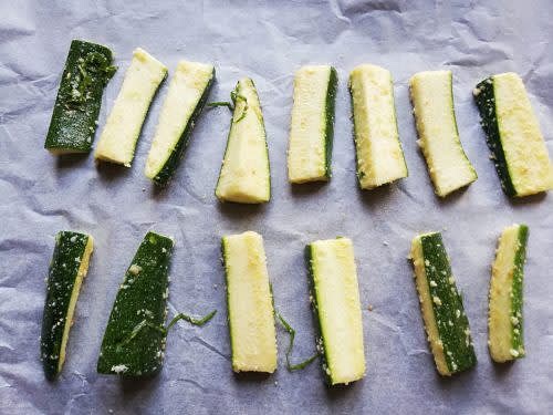 Sur la plaque du four couverte d’une feuille de papier sulfurisé, place les bâtonnets de courgette.
