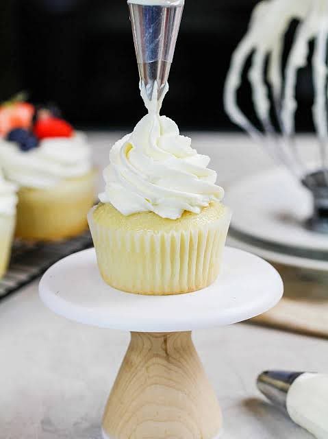 Decorate the cupcakes with whipped cream, then add some sprinkles