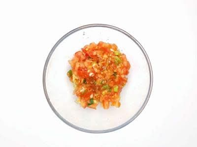 Boil a kettle Chop the tomatoes roughly Trim, then chop the spring onion[s] Mix the spring onion and tomatoes and chop them together for 30 sec until combined then add to a bowl with a pinch of salt and set aside – this is your tomato salsa