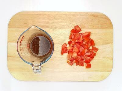 Meanwhile, dissolve the vegetable stock mix, dried basil, balsamic vinegar, tomato paste and 1 tsp [2 tsp] sugar in 100ml [150ml] boiled water – this is your stock Chop the tomato[es] roughly