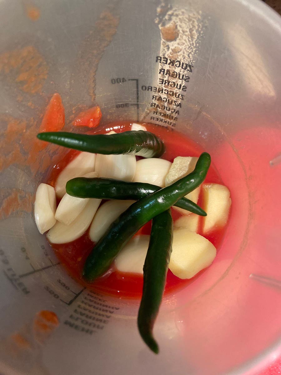 Put tomatoes garlic and ginger and green chillis into blender and blend