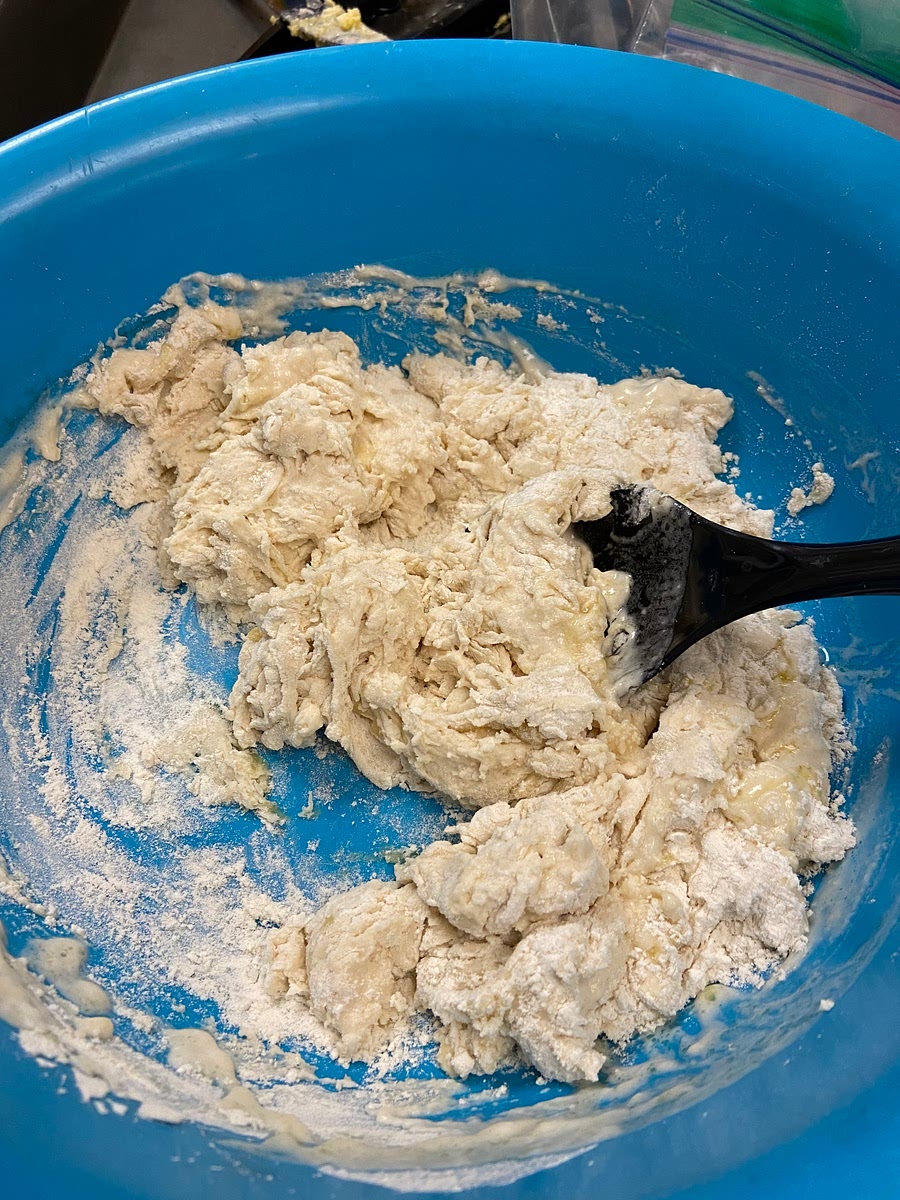 In a mixing bowl add in the flour, baking powder, and salt, whisk and then add in the olive oil and water. Mix with a large wooden spoon until it comes together and knead with your hand until it's a smooth dough. Add more flour if the dough is too sticky.