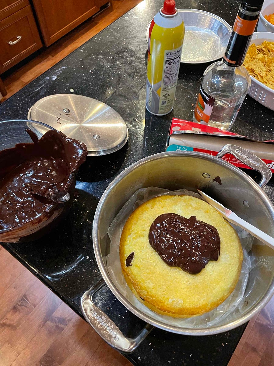 Put wax paper in deep stainless pot, add first cake layer w top on cake touching bottom of pan, spread chocolate sauce on top, add each additional cake w chocolate spread in between layers.
