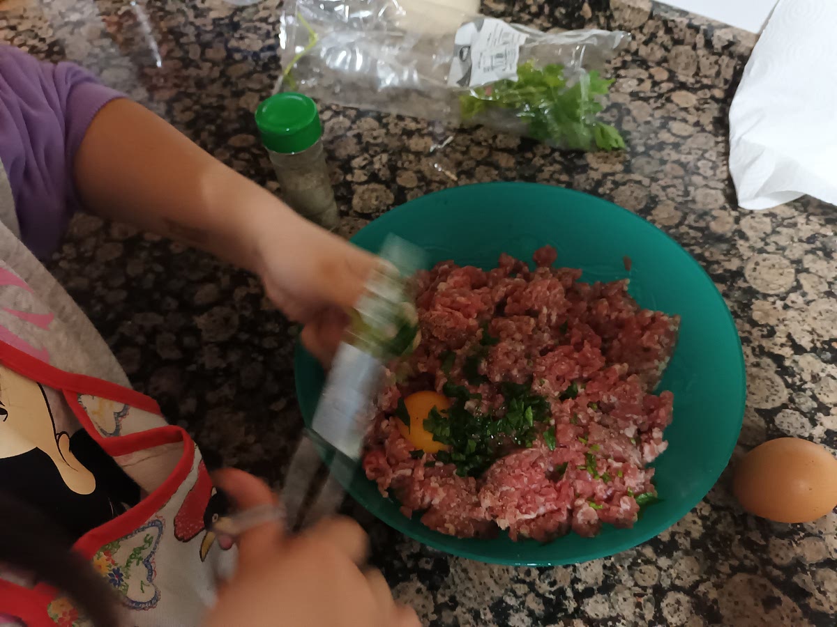 Echamos a la carne un huevo, el perejil picado y espolvoreamos pimentilla.