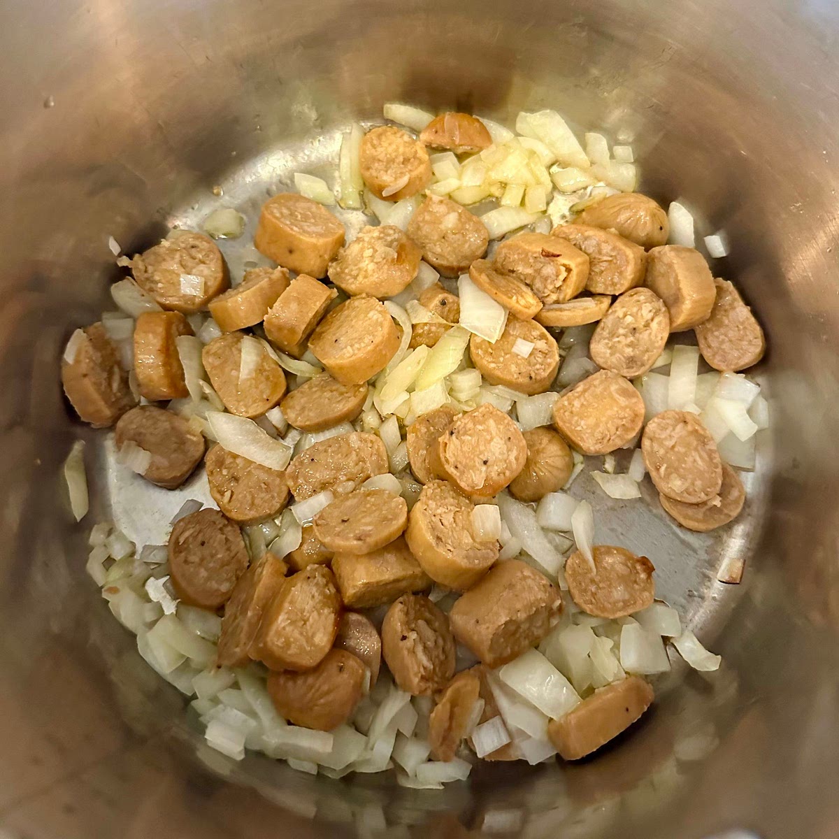 Sauté onions and vegan sausage.