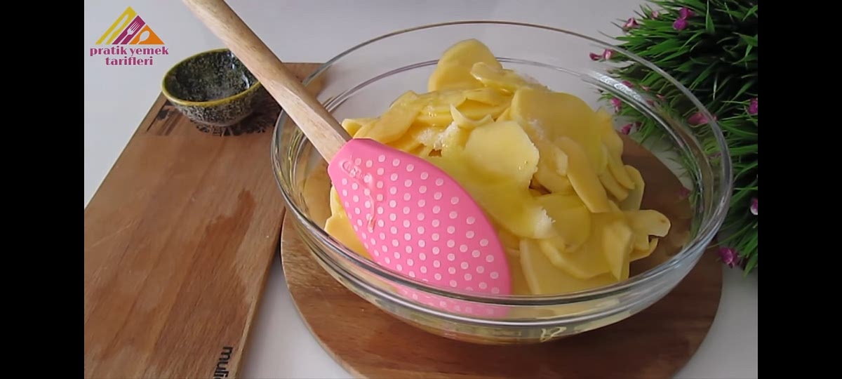 Pelar las patatas y cortarlas en láminas finas. Echarlas en un bol y añadir aceite y sal. Remover.
