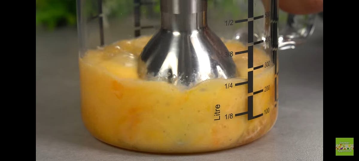 En un vaso echamos una mandarina pelada, dos huevos y una pizca de sal. Batimos con una batidora de mano eléctrica.