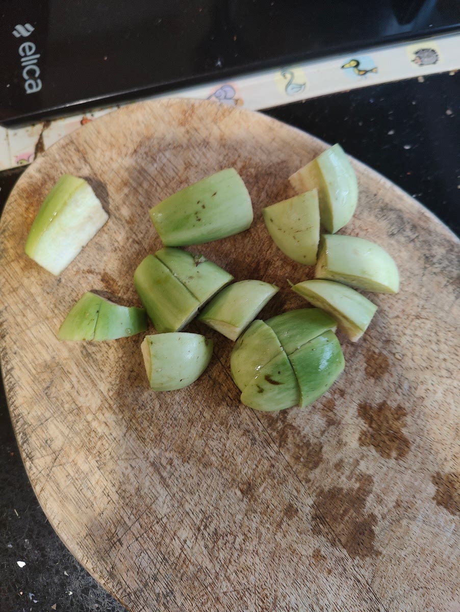 Cut up 2 Green Brinjals for thaan