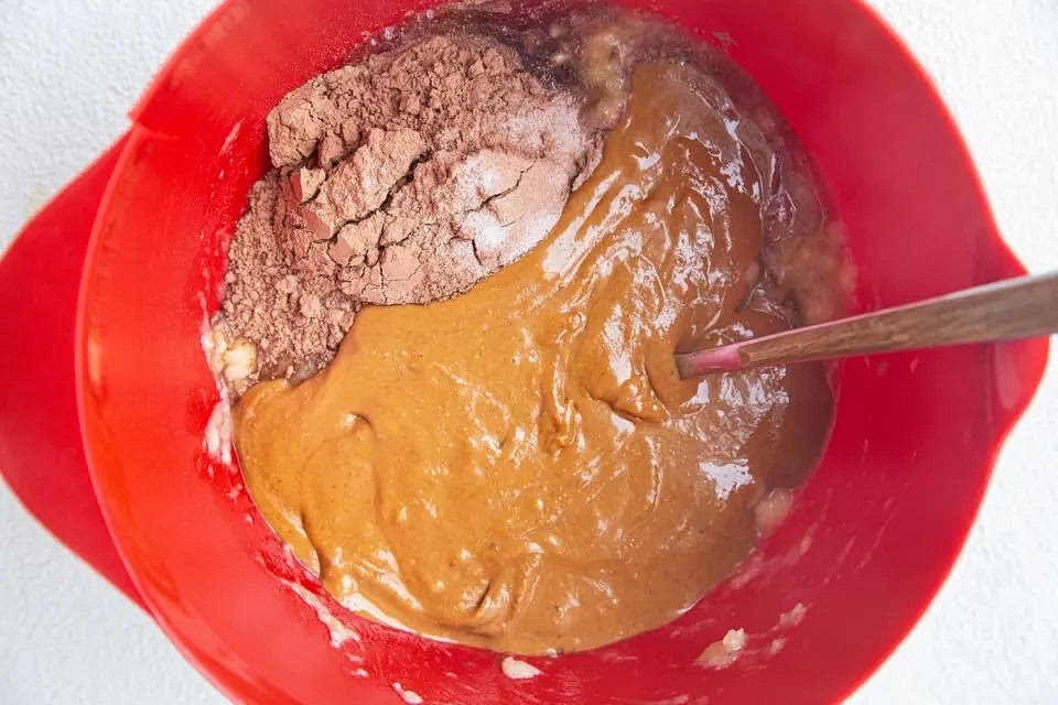 Add in the peanut butter, pure maple syrup, cocoa powder, and sea salt to the mixing bowl (the remaining ingredients) and stir well until a thick brownie batter forms.
