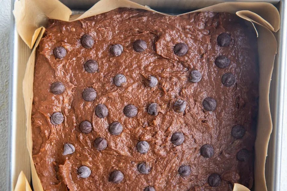 Pour batter into the prepared pan. Spread it into an even layer, and sprinkle with extra chocolate chips on top of the batter if you’d like.