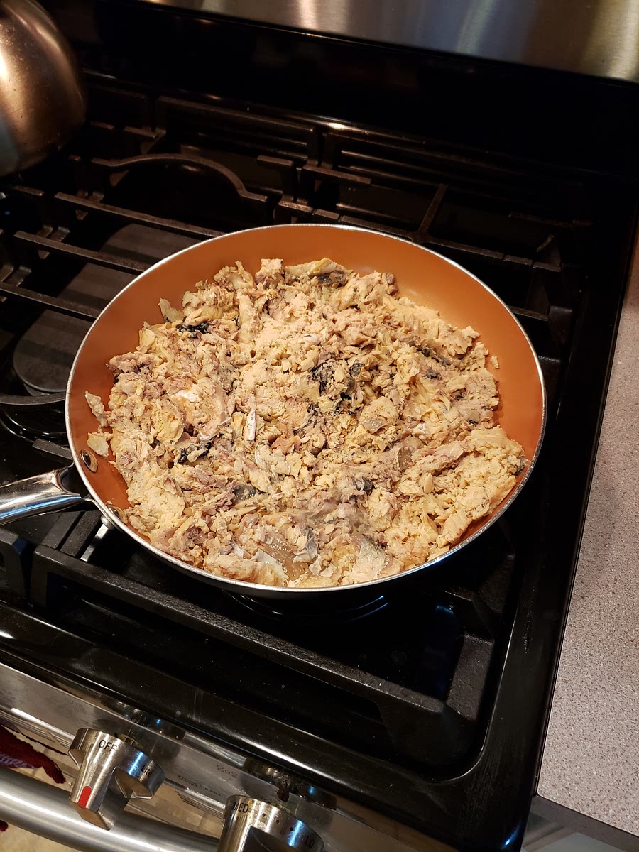 Add the salmon to a pan, break it into small pieces with a wooden spoon.