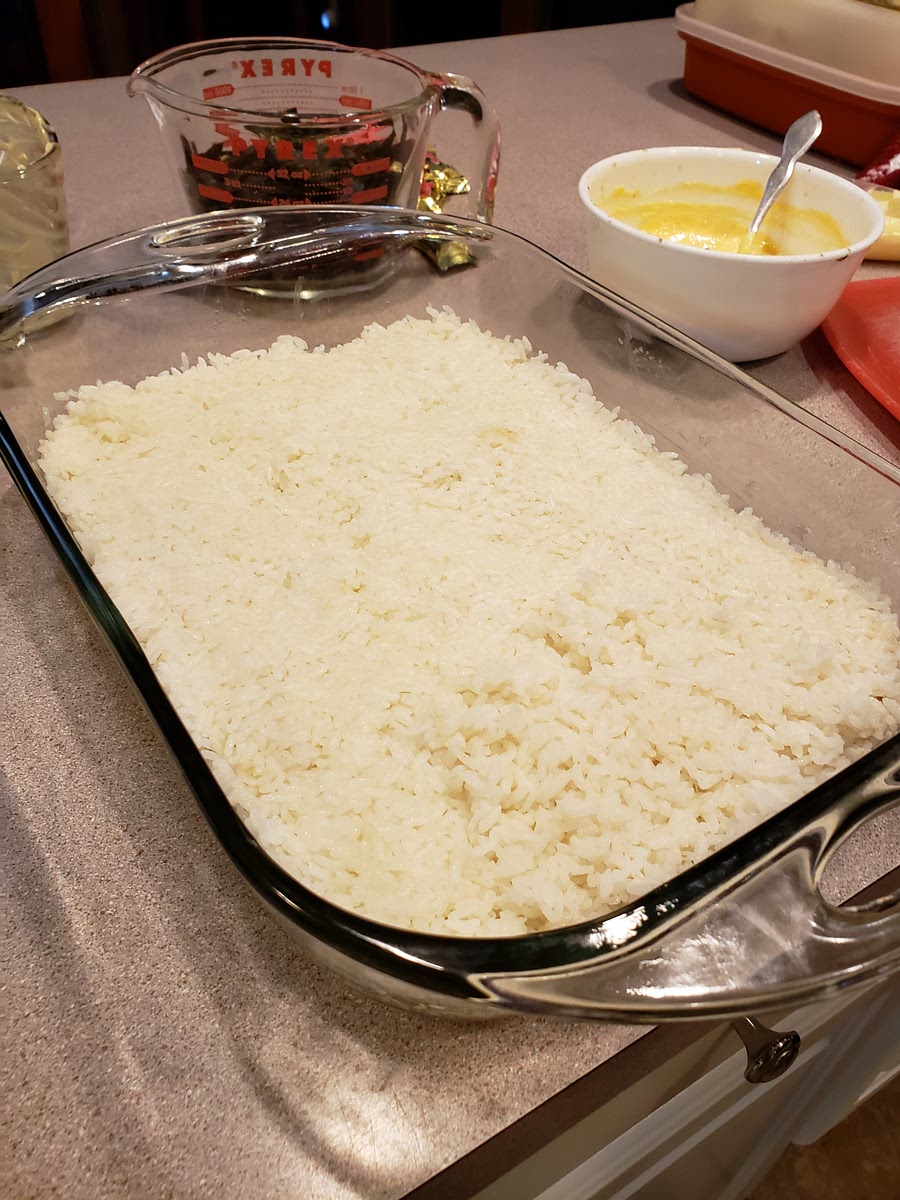 Add the rice to a deep cassarole dish, and then add butter (let it melt into the rice); then press the rice down firmly and evenly.