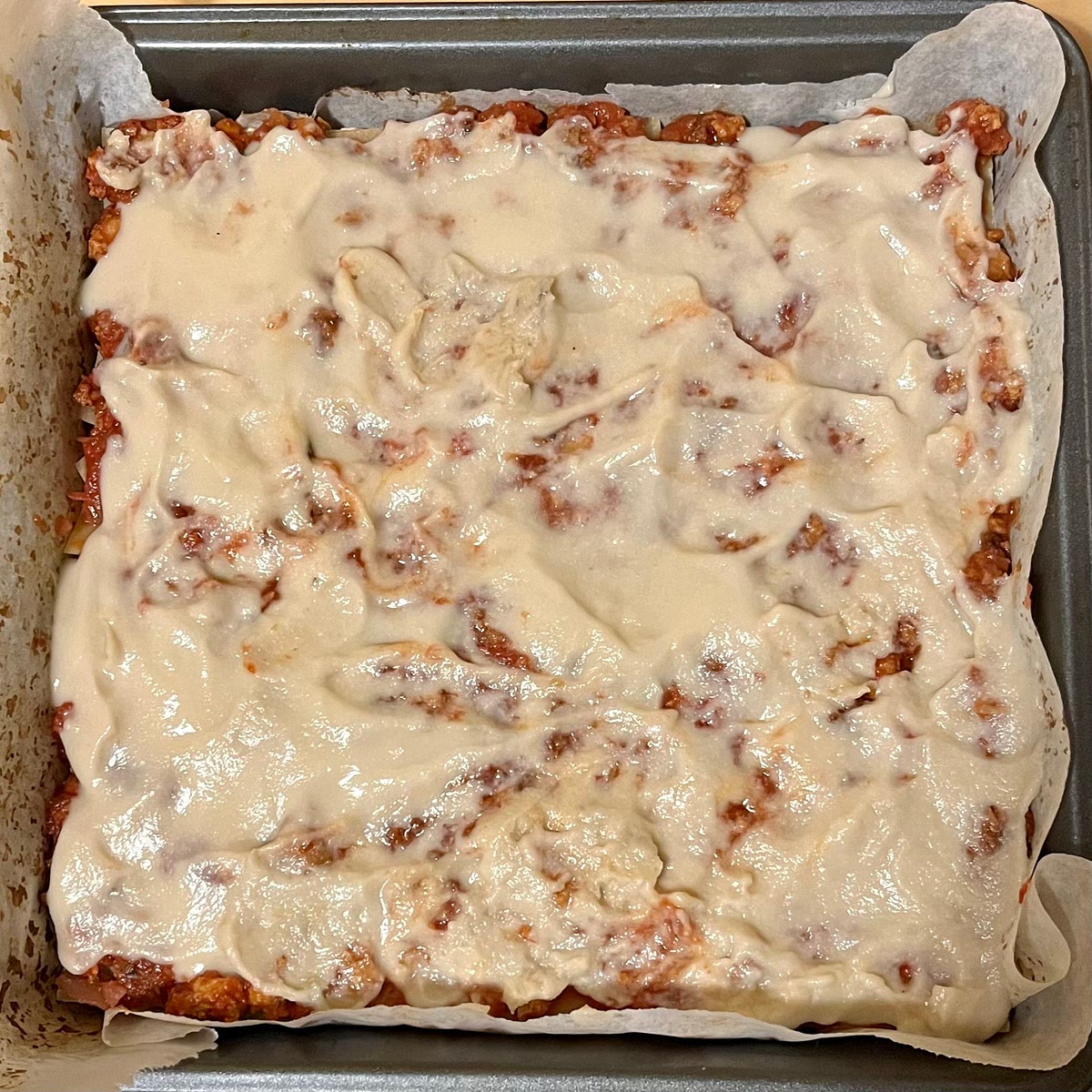 To assemble the lasagna, spread ¼ of the vegan meat sauce across the bottom of a 9"x13" pan. Top with 3 lasagna noodles. Spread another ¼ of vegan meat sauce over the noodles, then dollop ½ the ricotta over the meat sauce. Top with 3 more lasagna noodles, another ¼ of vegan meat sauce, the remaining ½ of the ricotta, 3 more lasagna noodles, the last of the vegan meat sauce, and lastly pour over all of the mozzarella sauce and gently spread it over top.