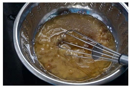 In a mixing bowl, whisk the mashed banana, sugar, oil and vanilla essence until combined.