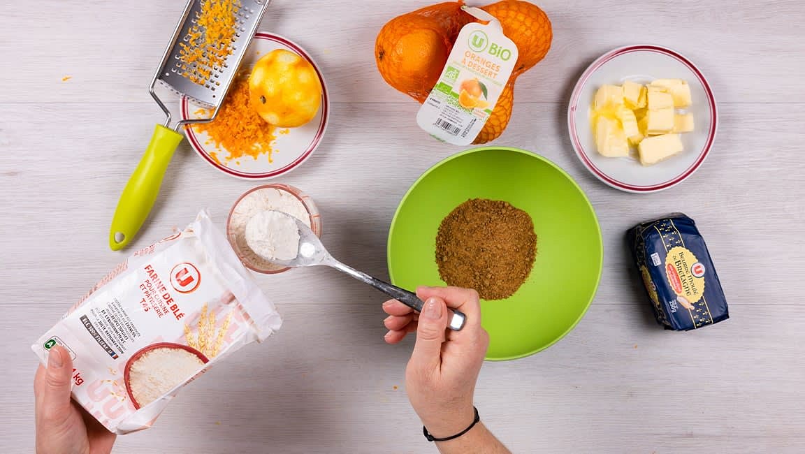 Brossez les 3 oranges sous un filet d’eau et essuyez-les. Râpez le zeste d’une orange et recueillez le jus. Préparez la pâte : dans un saladier ou le bol du robot muni du crochet pétrisseur, mélangez la farine avec le sucre, le zeste râpé de l’orange, le jaune d’œuf et le beurre. Malaxez en ajoutant un peu de jus d’orange (env. 5 cl) jusqu’à l’obtention d’une pâte lisse et homogène. Enveloppez-la de film alimentaire et réservez au frais au moins 30 minutes.