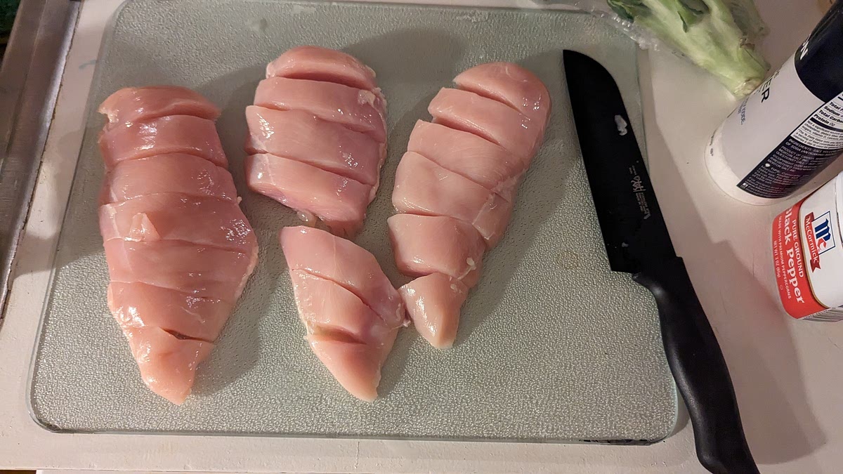 Make crosswise cuts every 1/2 inch along both chicken breasts, slicing almost to the bottom but not all the way through. Sprinkle chicken with l/4 teaspoon each salt and pepper. Fill the cuts alternately with tomato and mozzarella slices. Brush with pesto. Transfer the chicken to one side of the prepared baking sheet.